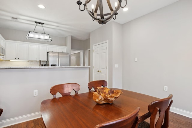 dining room with a notable chandelier and dark hardwood / wood-style floors