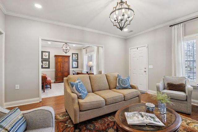 living room with hardwood / wood-style floors, ornamental molding, and a chandelier