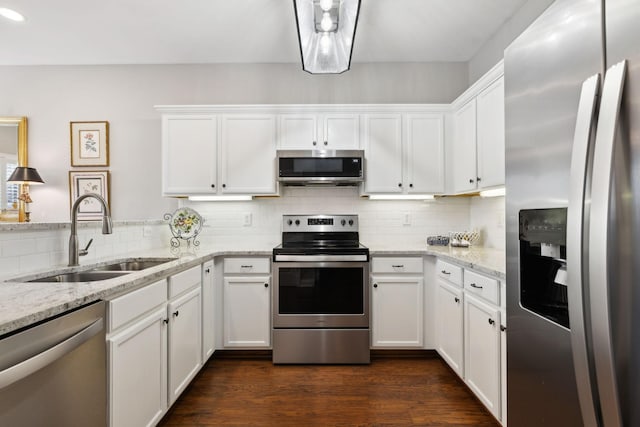 kitchen featuring sink, decorative backsplash, white cabinets, and appliances with stainless steel finishes