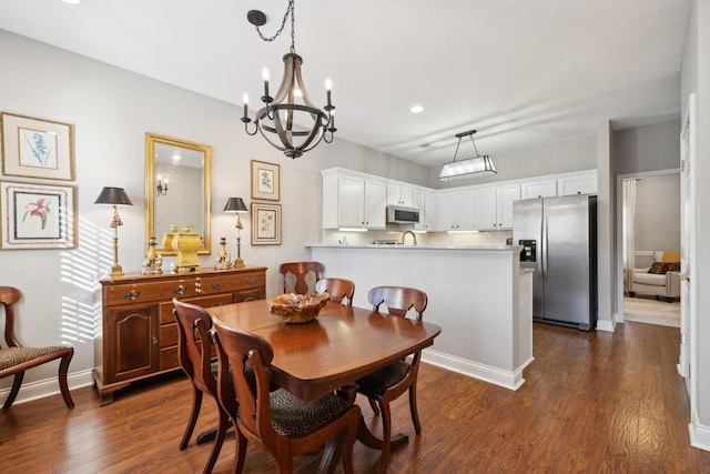 dining area featuring an inviting chandelier and dark wood-type flooring