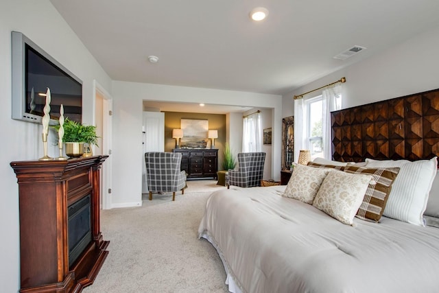 carpeted bedroom featuring a fireplace