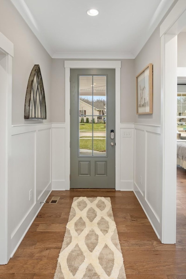 doorway to outside featuring wood-type flooring and crown molding