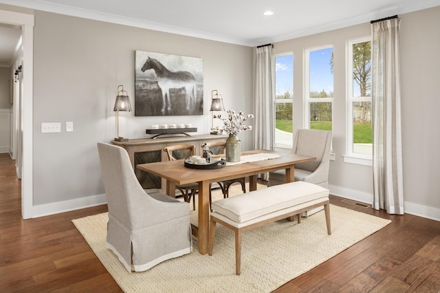 dining space with dark wood-type flooring and ornamental molding