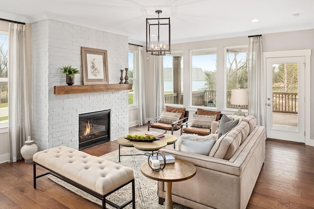 sunroom featuring a healthy amount of sunlight, a fireplace, and a notable chandelier