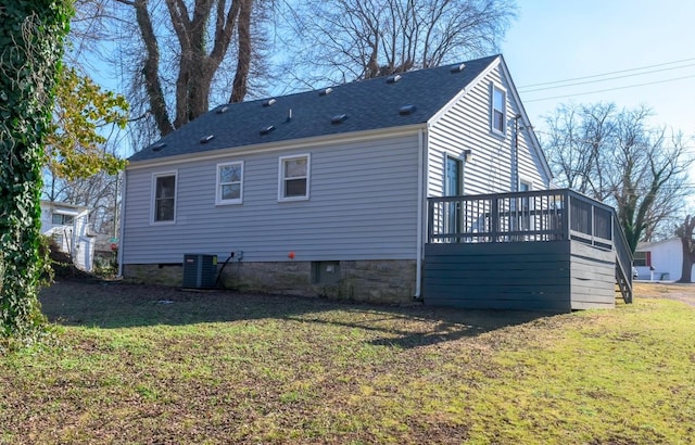 rear view of property featuring cooling unit, a wooden deck, and a lawn