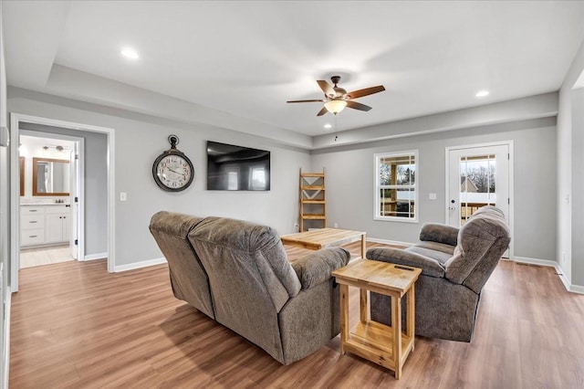 living room with light hardwood / wood-style floors and ceiling fan