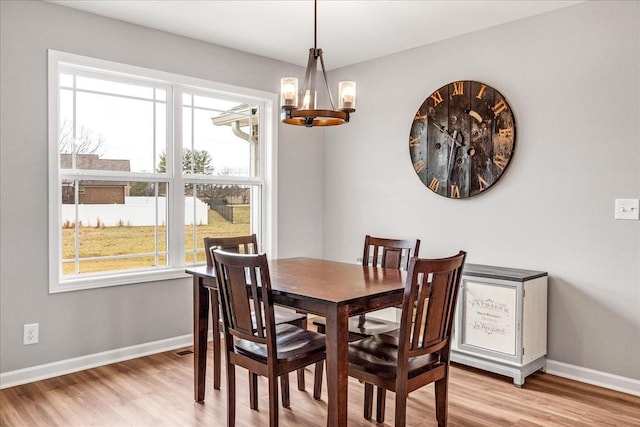 dining area with a chandelier and light wood-type flooring