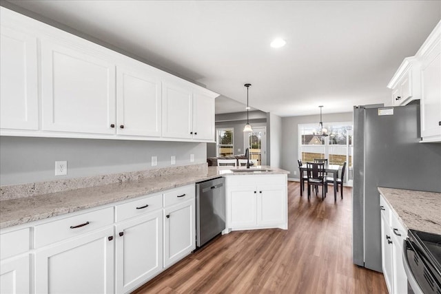 kitchen with stainless steel appliances, sink, pendant lighting, and white cabinets