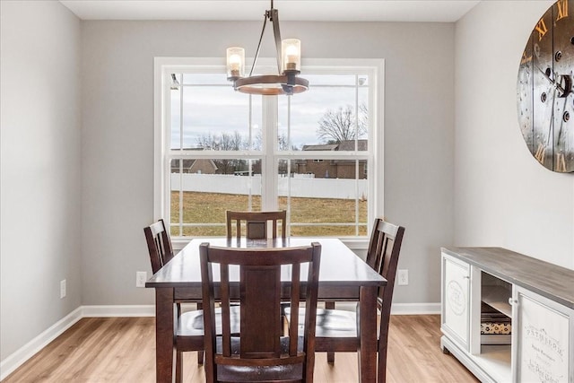 dining area with a chandelier, light wood-type flooring, and a wealth of natural light