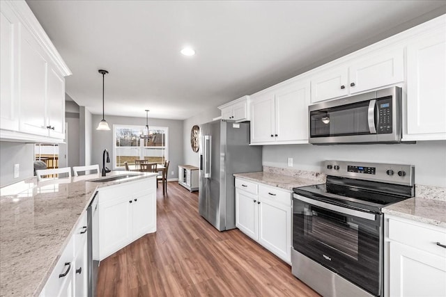 kitchen with white cabinetry, appliances with stainless steel finishes, sink, and hanging light fixtures