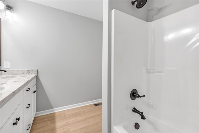 bathroom featuring vanity, hardwood / wood-style floors, and  shower combination