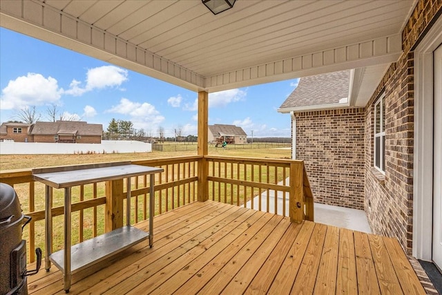 wooden terrace featuring a lawn