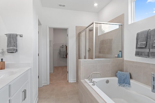 bathroom with vanity, tile patterned flooring, and plus walk in shower