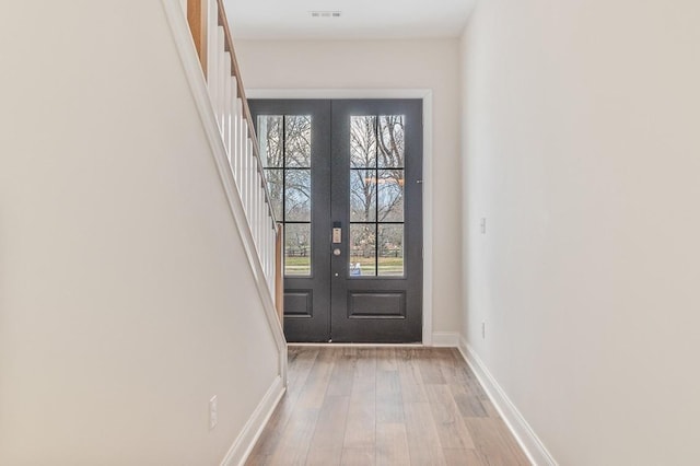 doorway to outside featuring french doors and light wood-type flooring