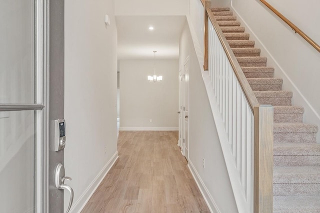 staircase featuring a chandelier and hardwood / wood-style floors