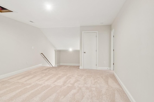 carpeted empty room with vaulted ceiling