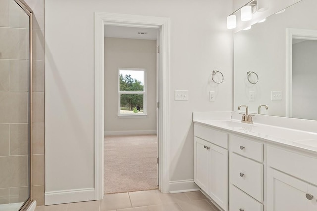 bathroom with tile patterned floors, a shower with door, and vanity