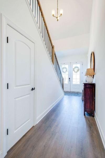 entryway with dark hardwood / wood-style floors and a notable chandelier