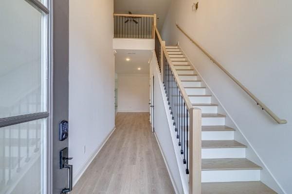 stairs with a high ceiling and hardwood / wood-style floors