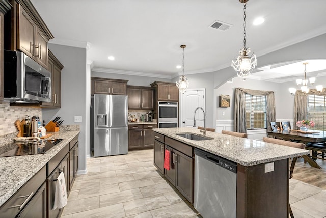 kitchen featuring sink, hanging light fixtures, a kitchen island with sink, stainless steel appliances, and dark brown cabinets