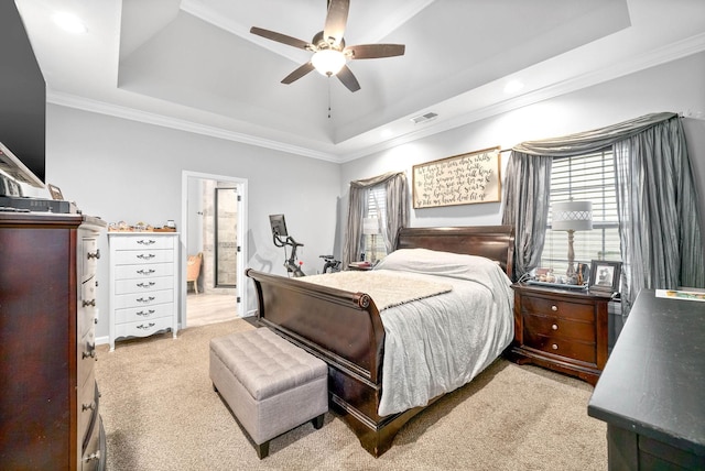 carpeted bedroom with multiple windows, a tray ceiling, crown molding, and ceiling fan