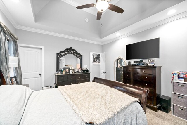 bedroom featuring a raised ceiling, ornamental molding, light carpet, and ceiling fan