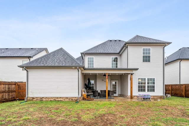 rear view of property featuring ceiling fan, a patio, and a lawn