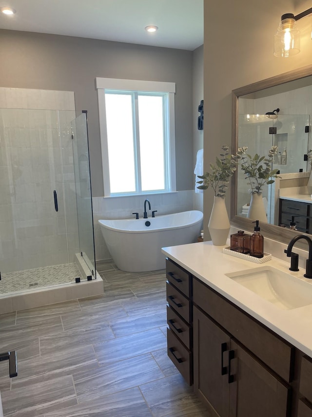 bathroom with vanity and separate shower and tub