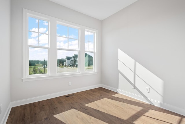 empty room with vaulted ceiling and hardwood / wood-style floors