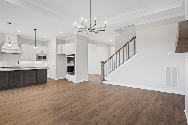 unfurnished living room with crown molding, sink, light hardwood / wood-style flooring, and a notable chandelier