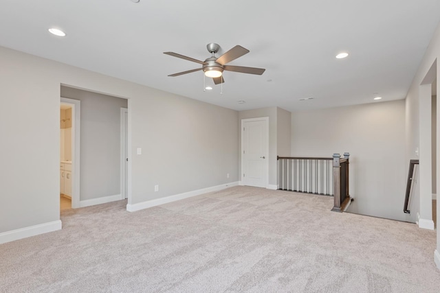 spare room featuring ceiling fan and light colored carpet