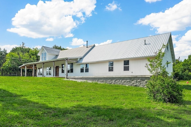 rear view of house featuring a yard and covered porch