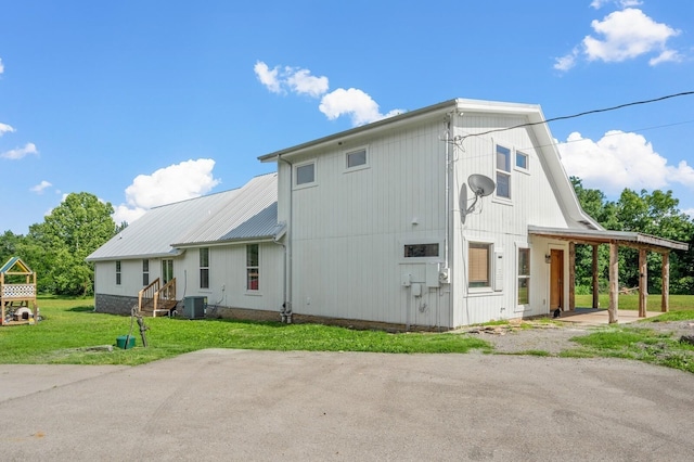 exterior space with cooling unit and a lawn