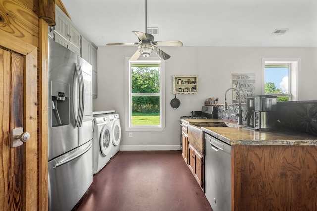 kitchen featuring stainless steel appliances, ceiling fan, a healthy amount of sunlight, and washer and clothes dryer