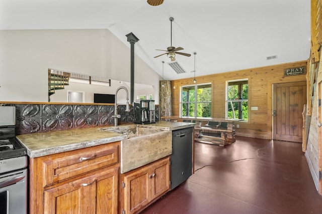 kitchen featuring sink, wood walls, high vaulted ceiling, appliances with stainless steel finishes, and pendant lighting