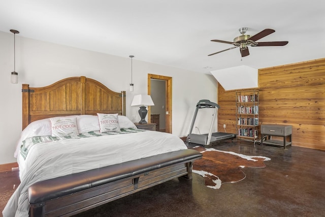 bedroom with ceiling fan and wood walls