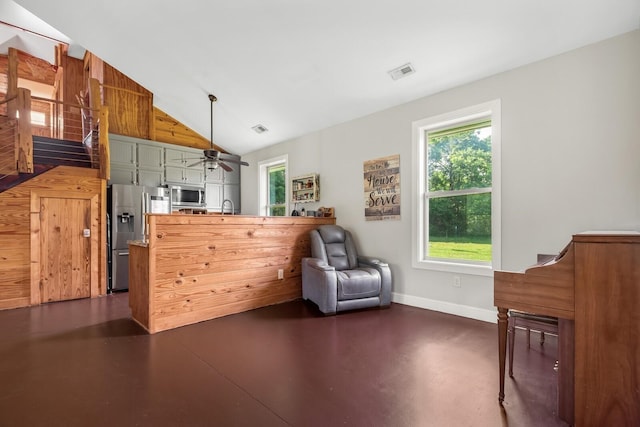 interior space with appliances with stainless steel finishes, kitchen peninsula, decorative light fixtures, lofted ceiling, and green cabinetry