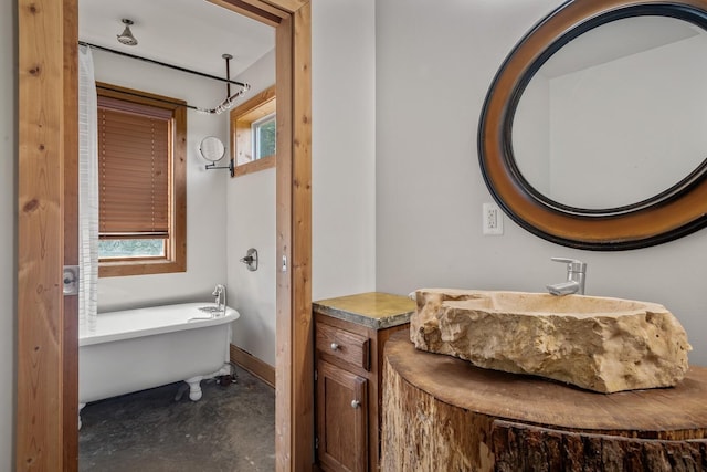 bathroom featuring sink, concrete floors, and a bathtub