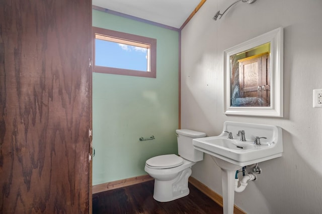 bathroom with crown molding, toilet, and hardwood / wood-style floors