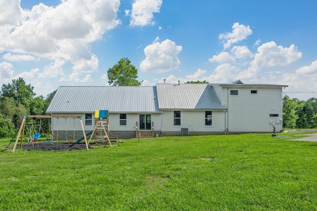 rear view of property featuring cooling unit, a yard, and a playground