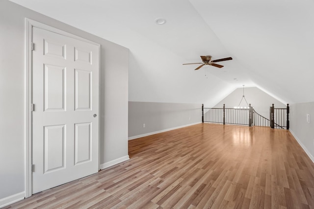 additional living space with light hardwood / wood-style flooring, vaulted ceiling, and ceiling fan