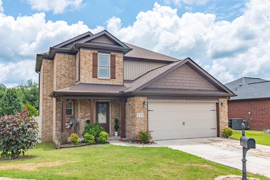 craftsman-style home with a garage, a front yard, and cooling unit