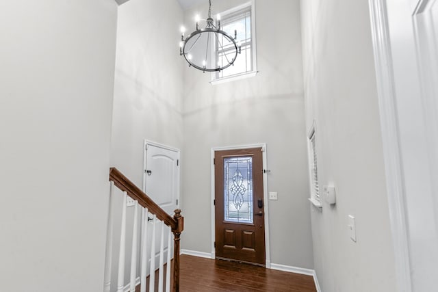 entrance foyer with a high ceiling, an inviting chandelier, and dark hardwood / wood-style flooring