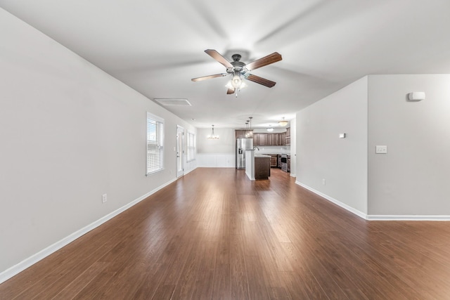 unfurnished living room with dark hardwood / wood-style floors and ceiling fan with notable chandelier