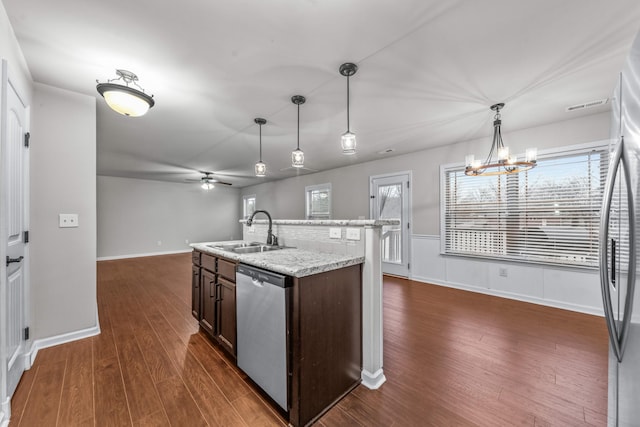 kitchen featuring appliances with stainless steel finishes, dark hardwood / wood-style floors, sink, hanging light fixtures, and dark brown cabinetry