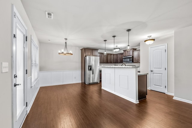 kitchen with stainless steel appliances, dark hardwood / wood-style floors, a center island, dark brown cabinetry, and decorative light fixtures