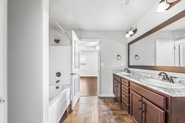 bathroom with washtub / shower combination, vanity, and tile patterned flooring