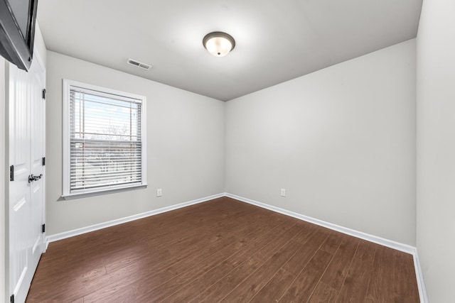 spare room with dark hardwood / wood-style flooring