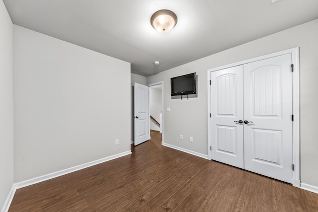 unfurnished bedroom featuring dark hardwood / wood-style flooring and a closet