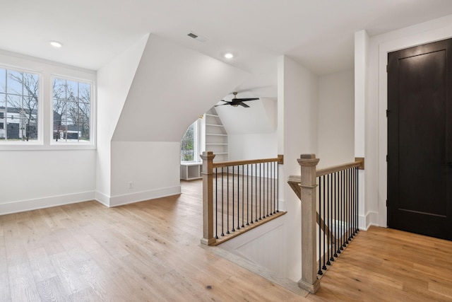 bonus room featuring ceiling fan, built in features, vaulted ceiling, and light hardwood / wood-style flooring